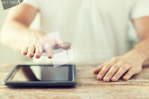 Image of close up of male hands with tablet pc on table