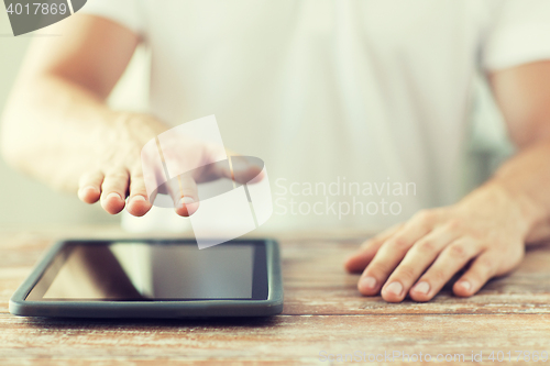 Image of close up of male hands with tablet pc on table