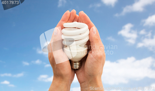 Image of close up of hands holding energy saving lightbulb