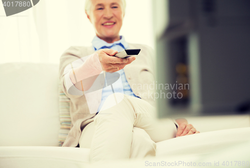 Image of close up of happy senior woman watching tv at home