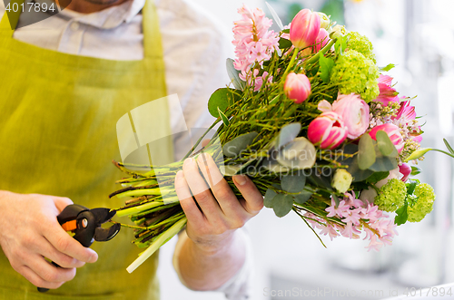 Image of close up of florist man with flowers and pruner