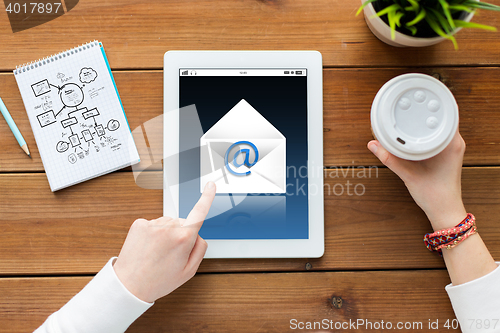 Image of close up of woman with tablet pc on wooden table