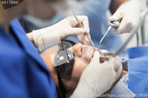 Image of close up of dentists treating teeth at clinic