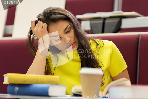 Image of student girl with books and coffee on lecture