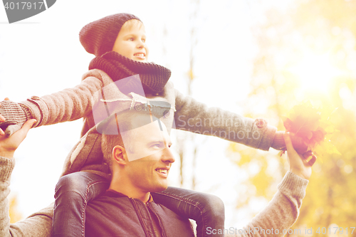 Image of happy family having fun in autumn park