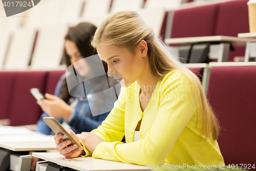 Image of student girls with smartphones on lecture