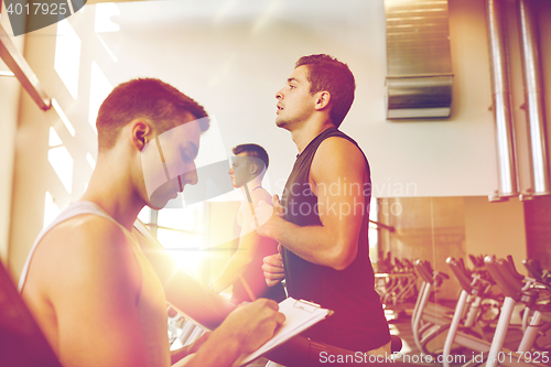 Image of men exercising on treadmill in gym