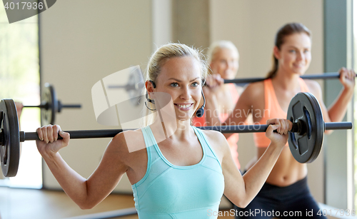 Image of group of women with barbells exercising in gym