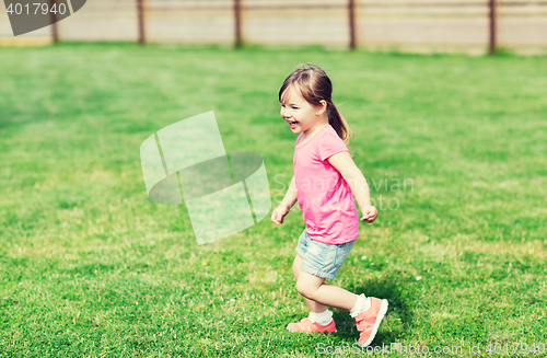 Image of happy little girl running on green summer field