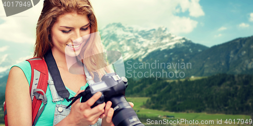 Image of woman with backpack and camera over mountains