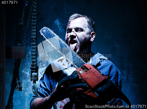 Image of Bloody Halloween theme: crazy killer as butcher with electric saw