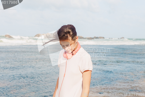 Image of Woman walking on the beach sand