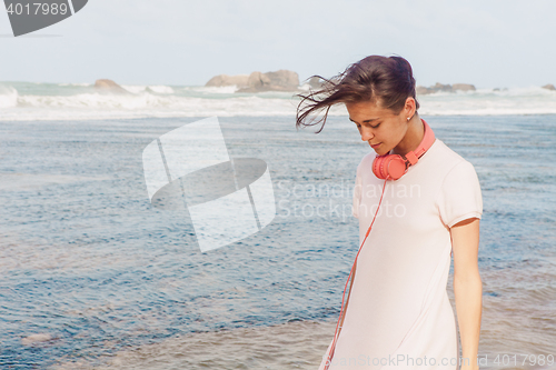 Image of Woman walking on the beach sand