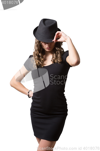 Image of Joyful pretty girl wearing black dress and classic hat smiling at camera. Beauty, fashion concept. Isolated white background