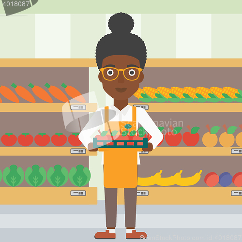 Image of Supermarket worker with box full of apples.