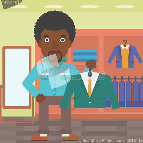 Image of Man holding suit jacket in clothing store.