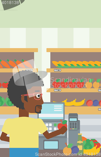 Image of Cashier standing at the checkout in supermarket.