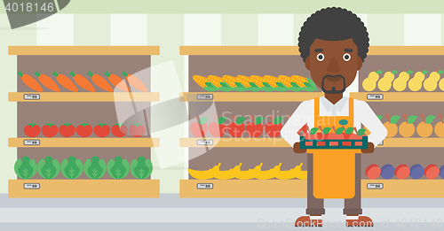 Image of Supermarket worker with box full of apples.