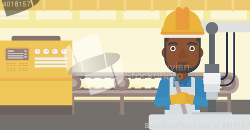 Image of Man working on industrial drilling machine.