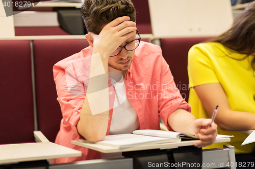 Image of group of students with notebooks in lecture hall