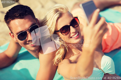 Image of happy couple in swimwear walking on summer beach