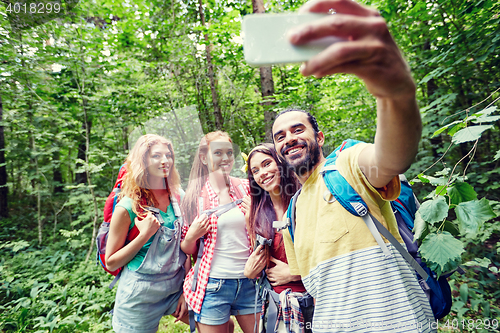 Image of friends with backpack taking selfie by smartphone