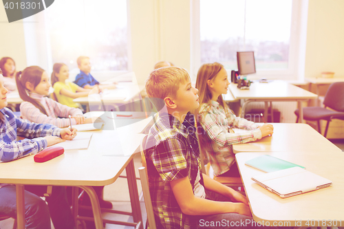 Image of group of school kids with notebooks in classroom