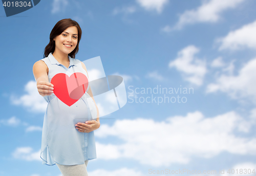 Image of happy pregnant woman with red heart touching belly