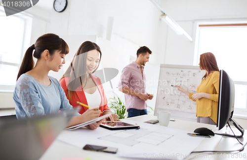 Image of happy creative team with tablet pc at office