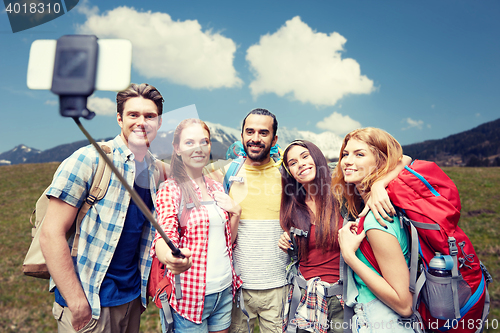 Image of friends with backpack taking selfie by smartphone