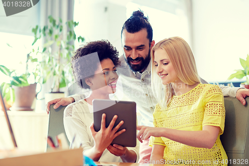 Image of happy creative team with tablet pc in office