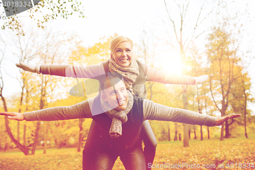 Image of smiling couple having fun in autumn park