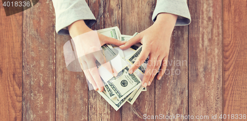 Image of close up of woman hands counting us dollar money