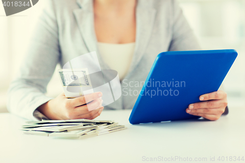 Image of close up of woman hands with tablet pc and money