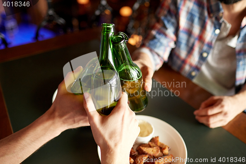 Image of close up of friends drinking beer at bar or pub