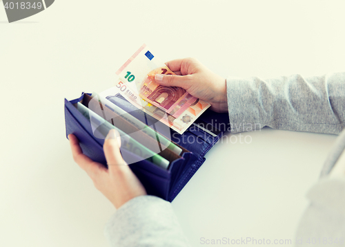 Image of close up of woman hands with wallet and euro money