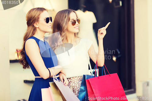 Image of happy young women with shopping bags in mall