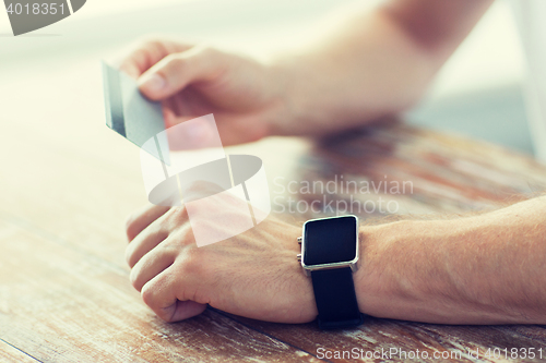 Image of close up of hands with smart watch and credit card