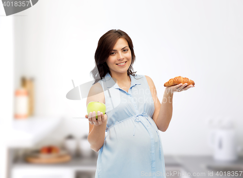 Image of happy pregnant woman with apple and croissant