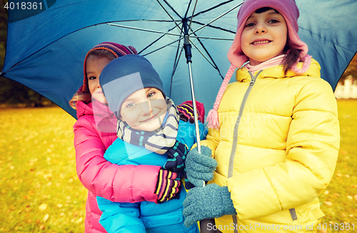 Image of happy children with umbrella in autumn park