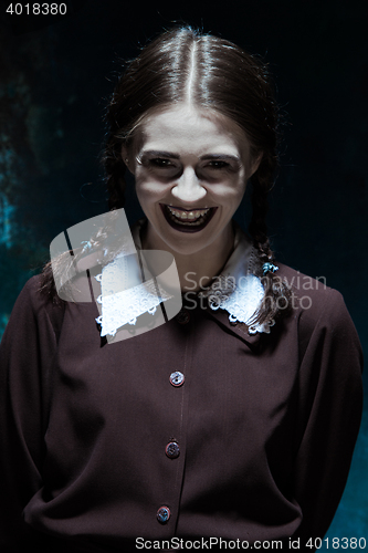 Image of Portrait of a young smiling girl in school uniform as killer woman