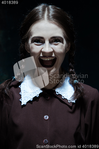 Image of Portrait of a young smiling girl in school uniform as killer woman