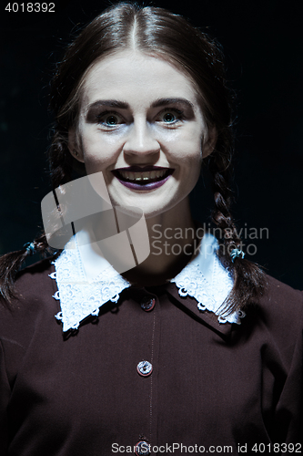 Image of Portrait of a young smiling girl in school uniform as killer woman