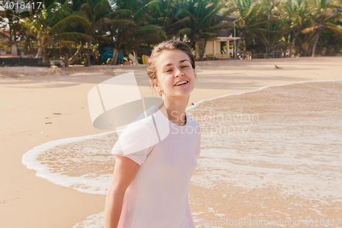 Image of Woman legs walking on the beach sand