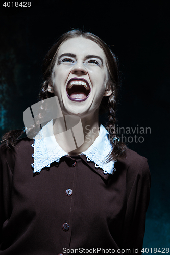 Image of Portrait of a young smiling girl in school uniform as killer woman