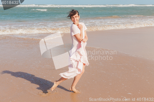 Image of Woman legs walking on the beach sand