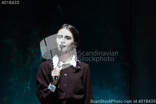 Image of Portrait of a young girl in school uniform as killer woman