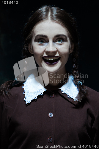 Image of Portrait of a young smiling girl in school uniform as killer woman