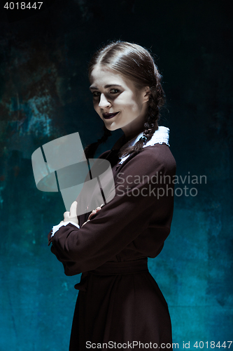Image of Portrait of a young smiling girl in school uniform as killer woman