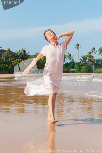 Image of Woman legs walking on the beach sand